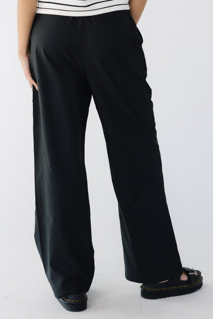 Back view of a young woman wearing wide leg pants.
