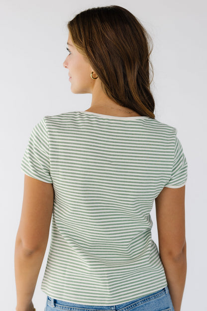 Back view of a woman wearing an ivory and green double stripe closer fitting knit top with short sleeves.