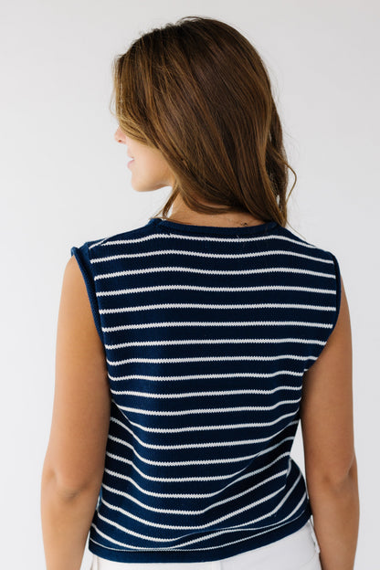 Back view of a woman wearing a navy and white stripe sweater vest with a round neckline.