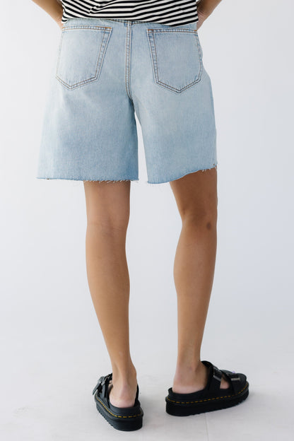 Back view of a woman wearing wide leg jeans with scissor cut hems.