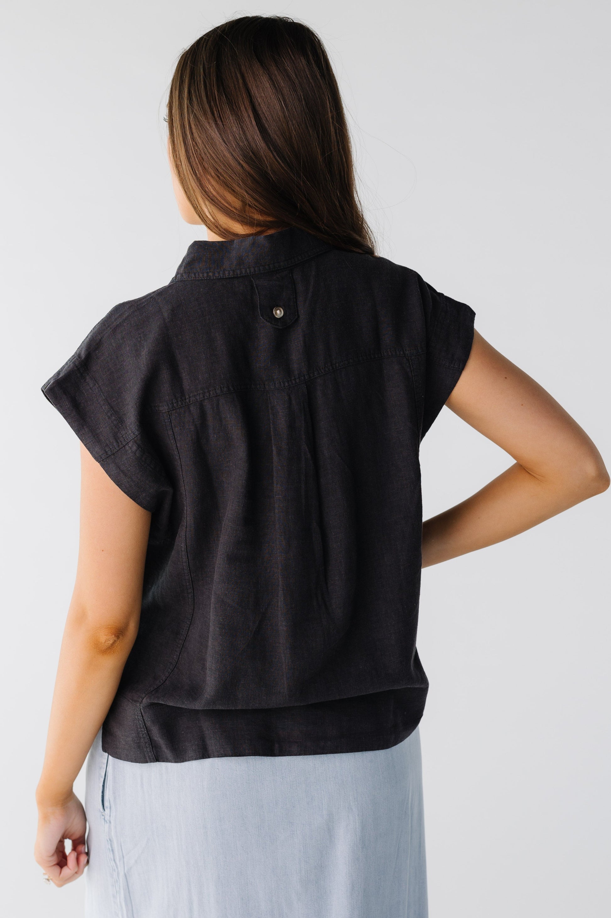 Back view of black woven loose fitting top