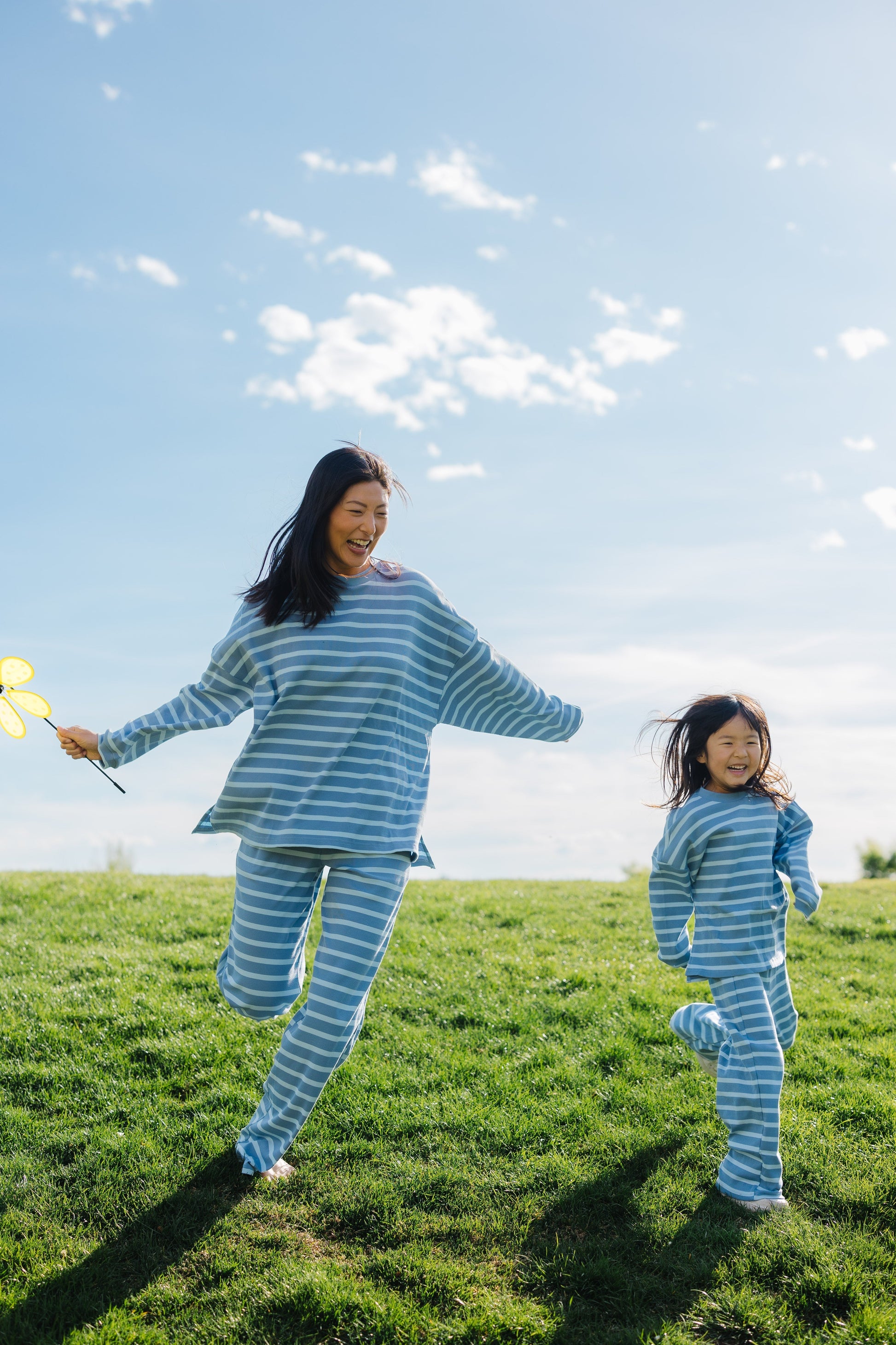 Woman and little girl wearing loose fitting, matching light blue lounge sets.