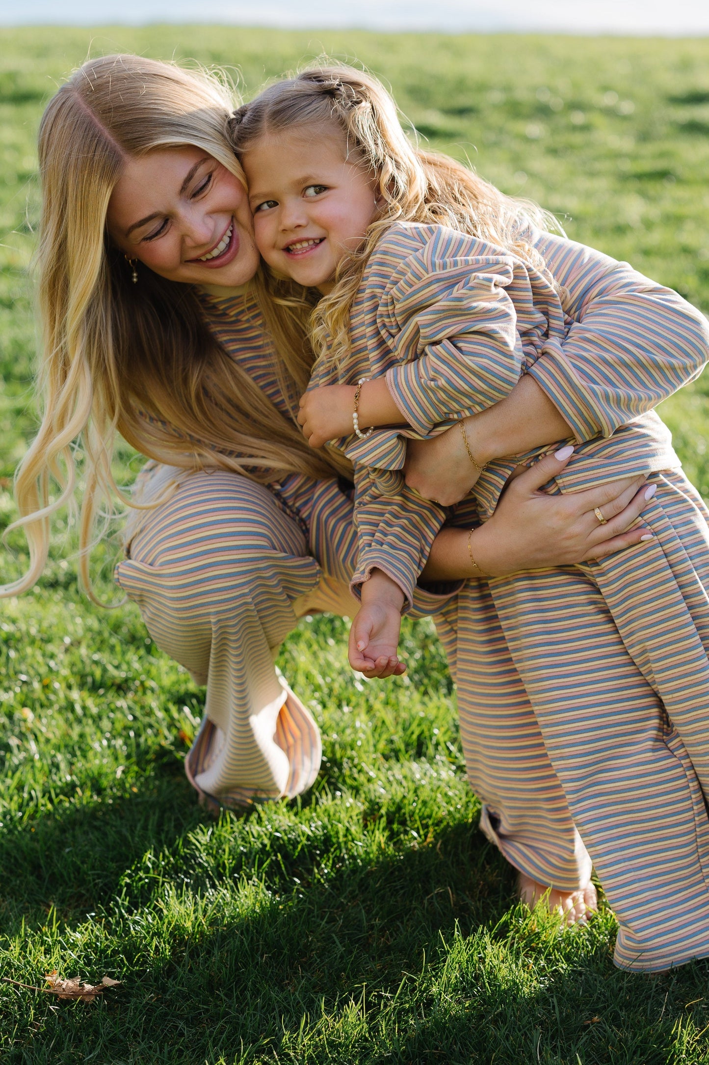 Mom & me wearing matching lounge sets in cream, blue and pink stripe.