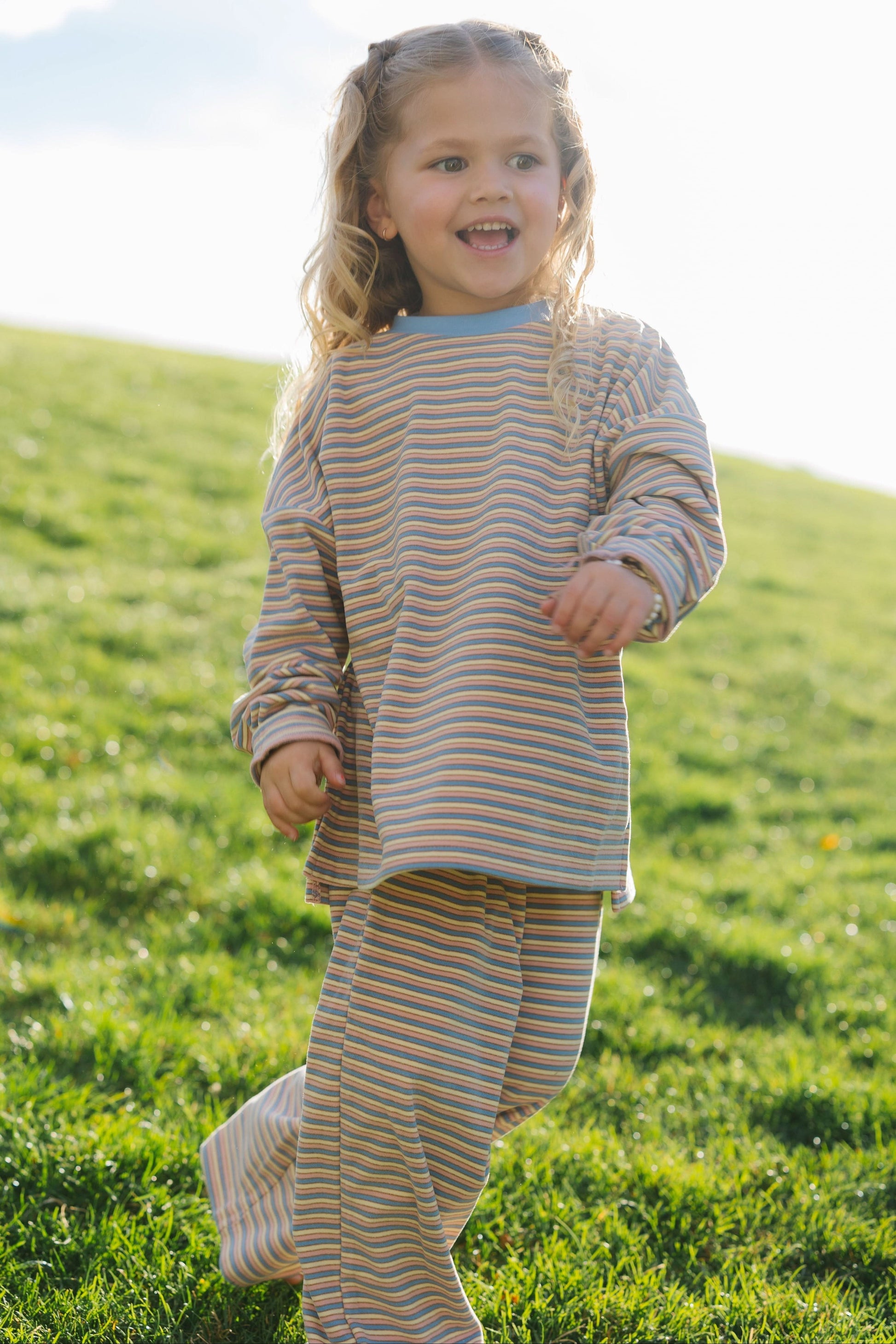 Young girl wearing a modest 2 piece lounge set in cream, blue, and pink for girls size 2-12.
