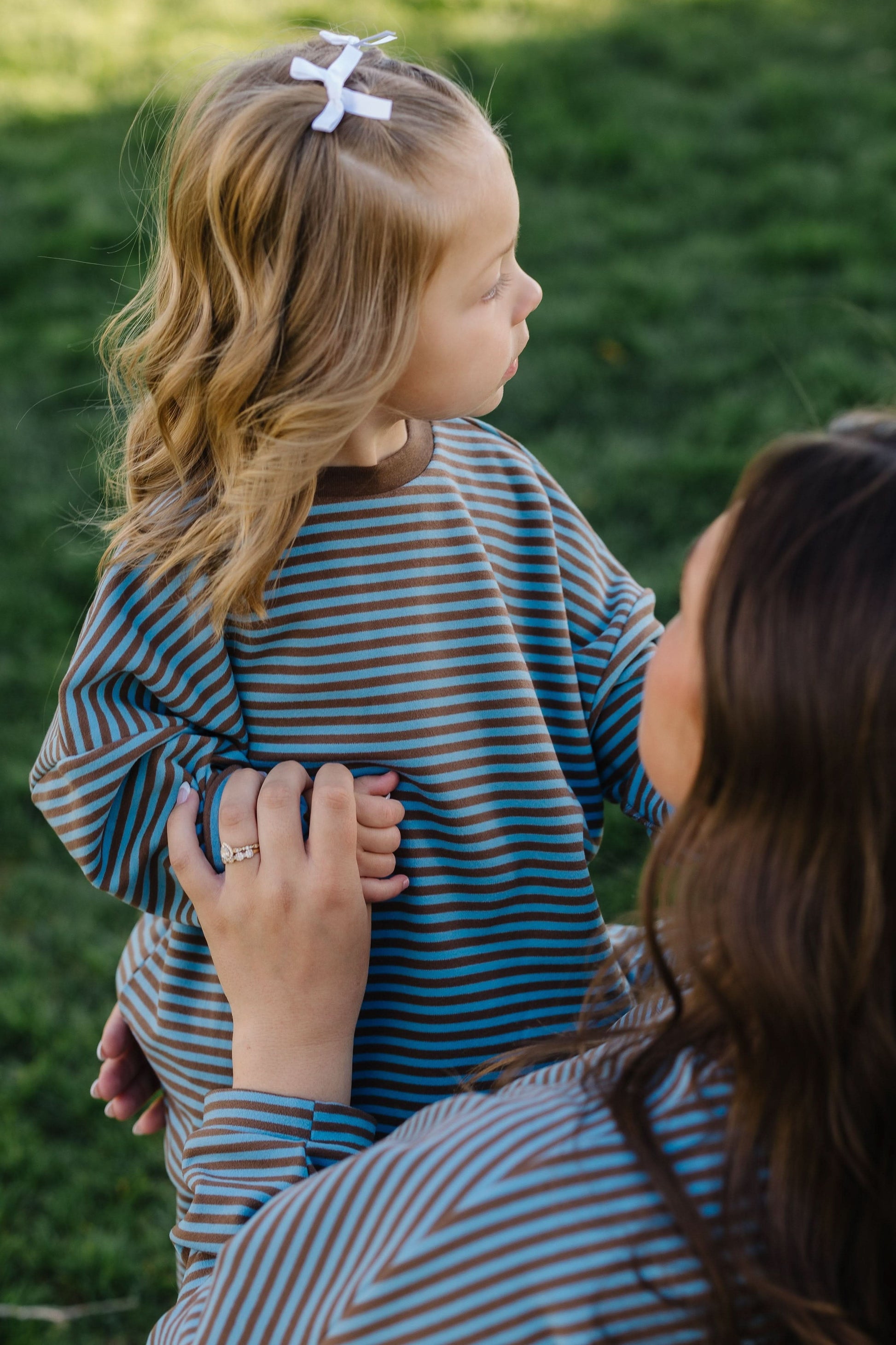 Little girl wearing a blue & brown loose fitting lounge set with long sleeves and long pants.