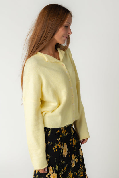 A women in a soft yellow button cardigan in light yellow