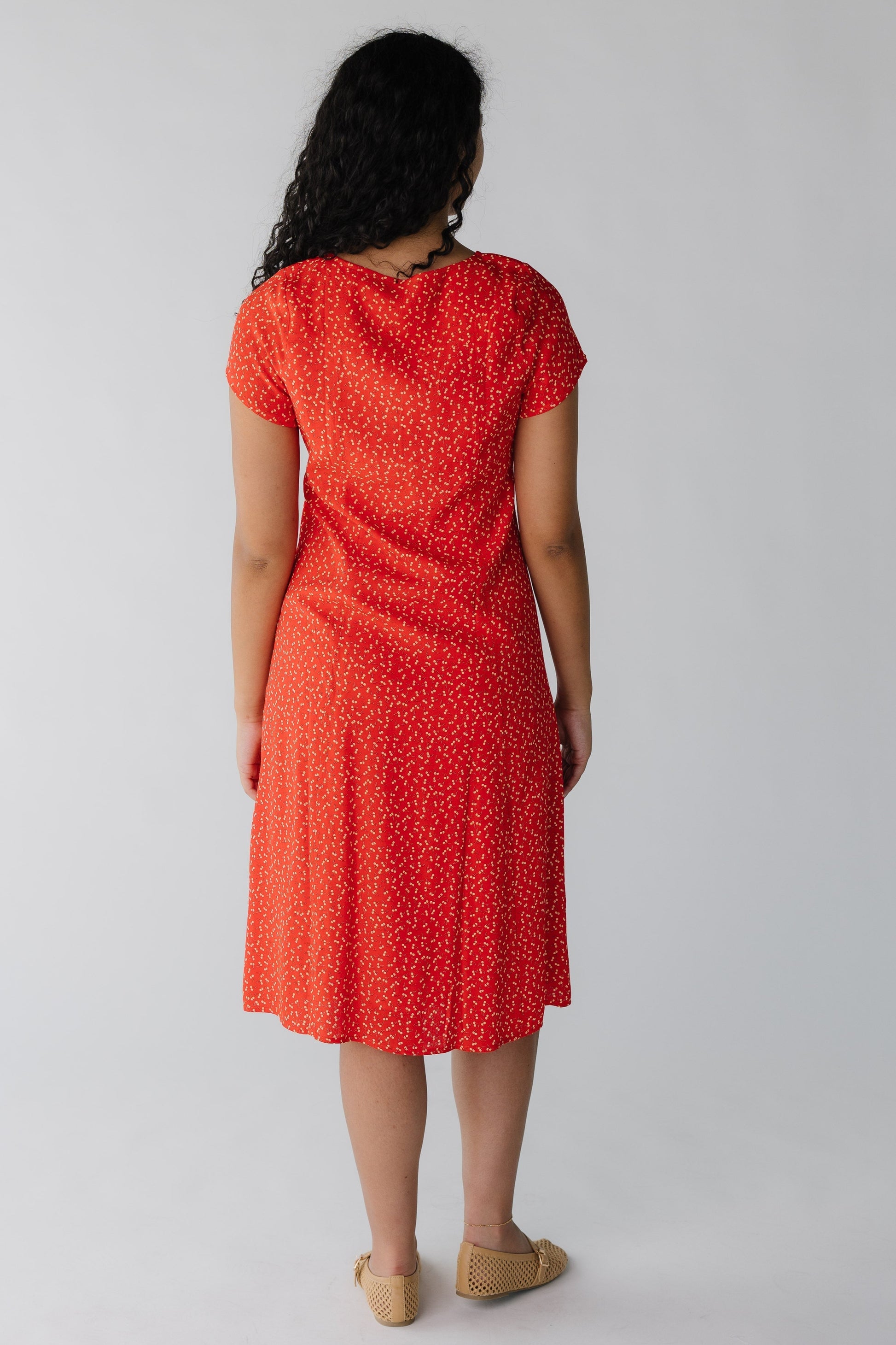 Back view of red cherry print midi with short sleeves