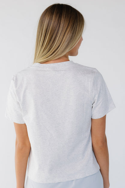 Back view of a woman wearing a heather grey short sleeve tee.