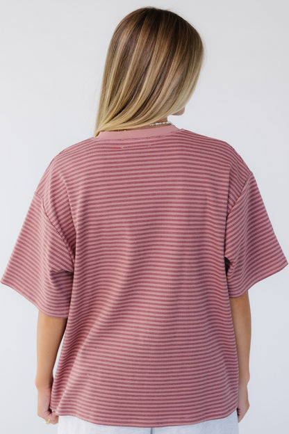 Back view of a woman wearing a short sleeve, loose fitting tee.