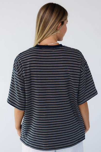 Back view of a woman wearing a navy stripe short sleeve tee.