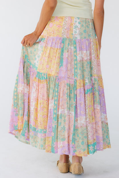 Back view of a woman wearing a pastel tiered midi skirt by Billabong.