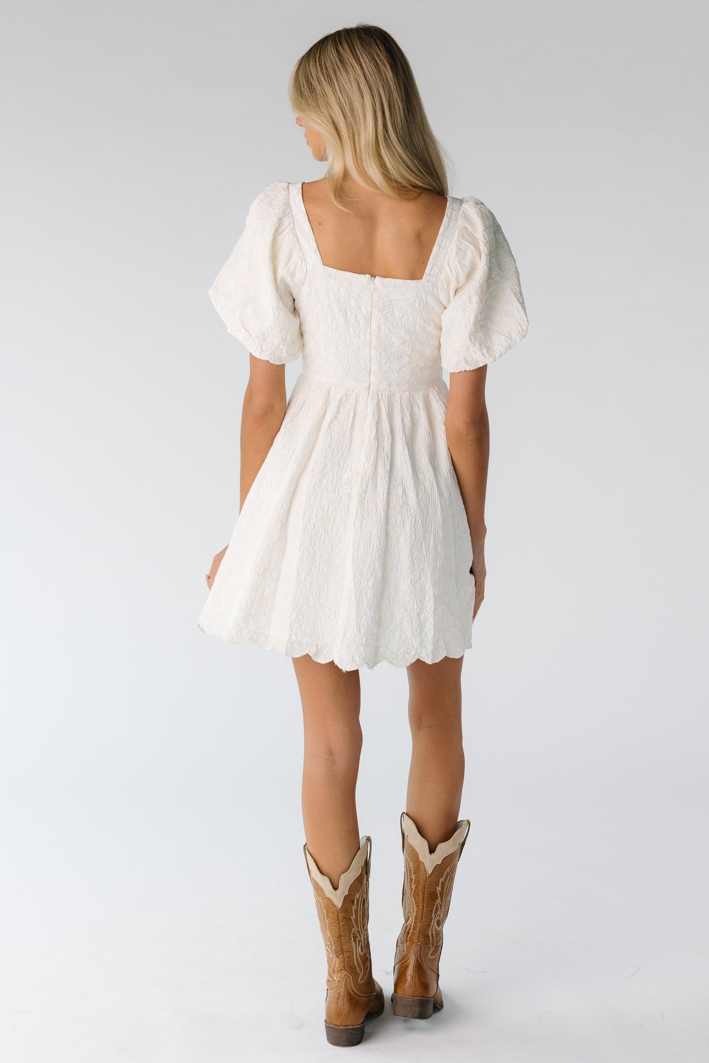 Back view of square neck mini dress in cream with cream embroidery 
