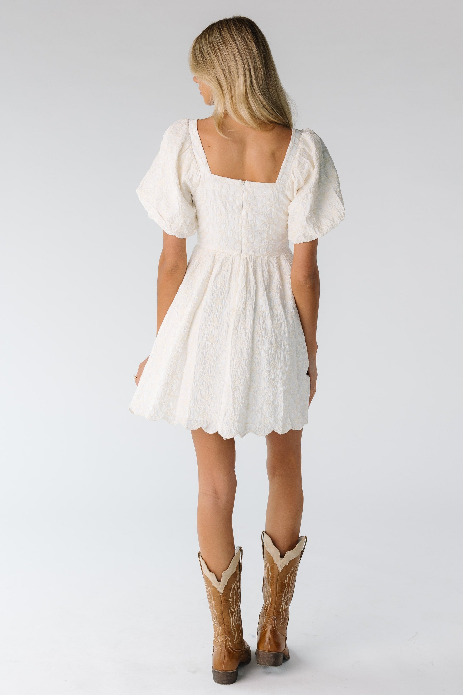 Back view of square neck mini dress in cream with cream embroidery 