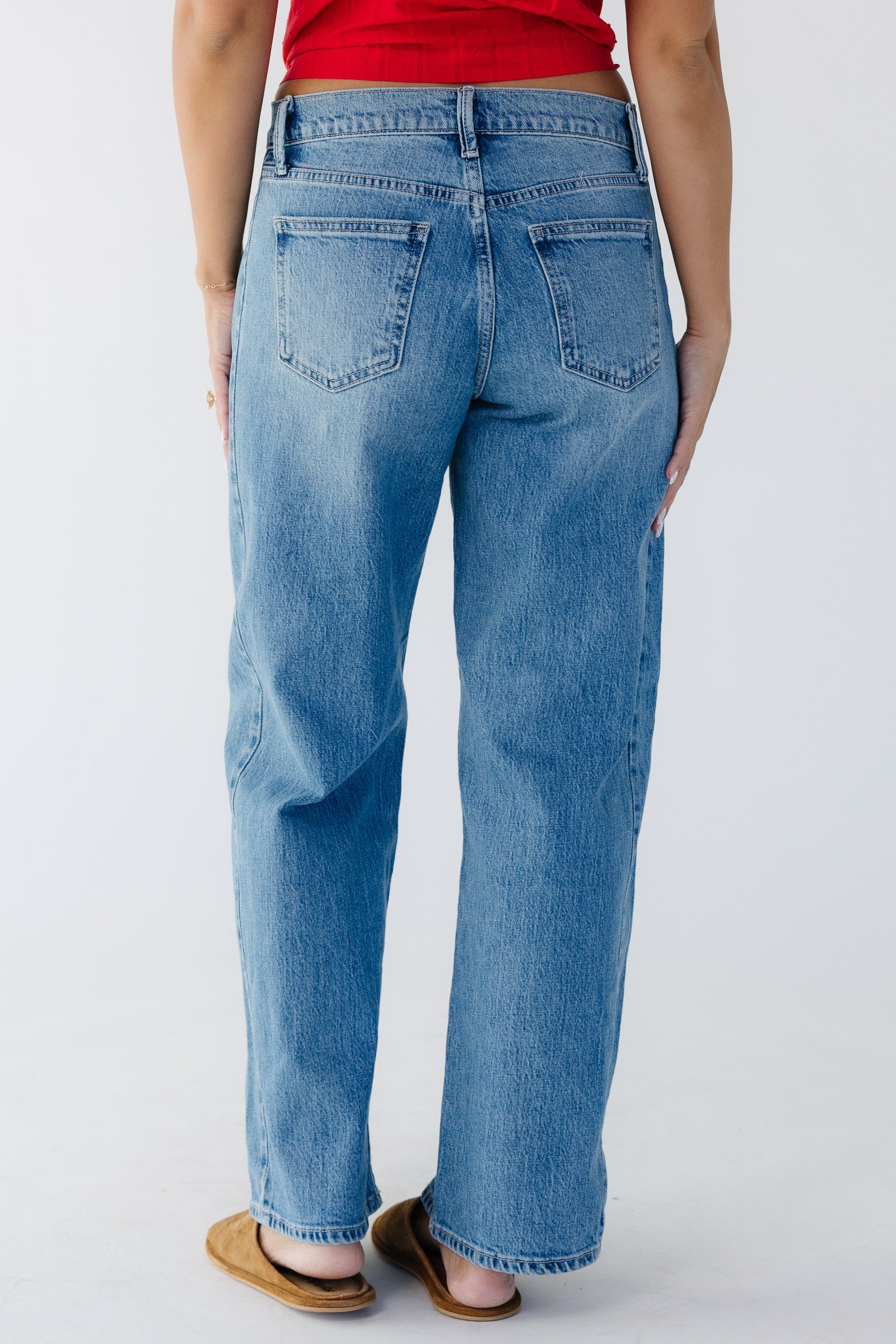 Back view of a woman wearing wide leg jeans in medium denim.