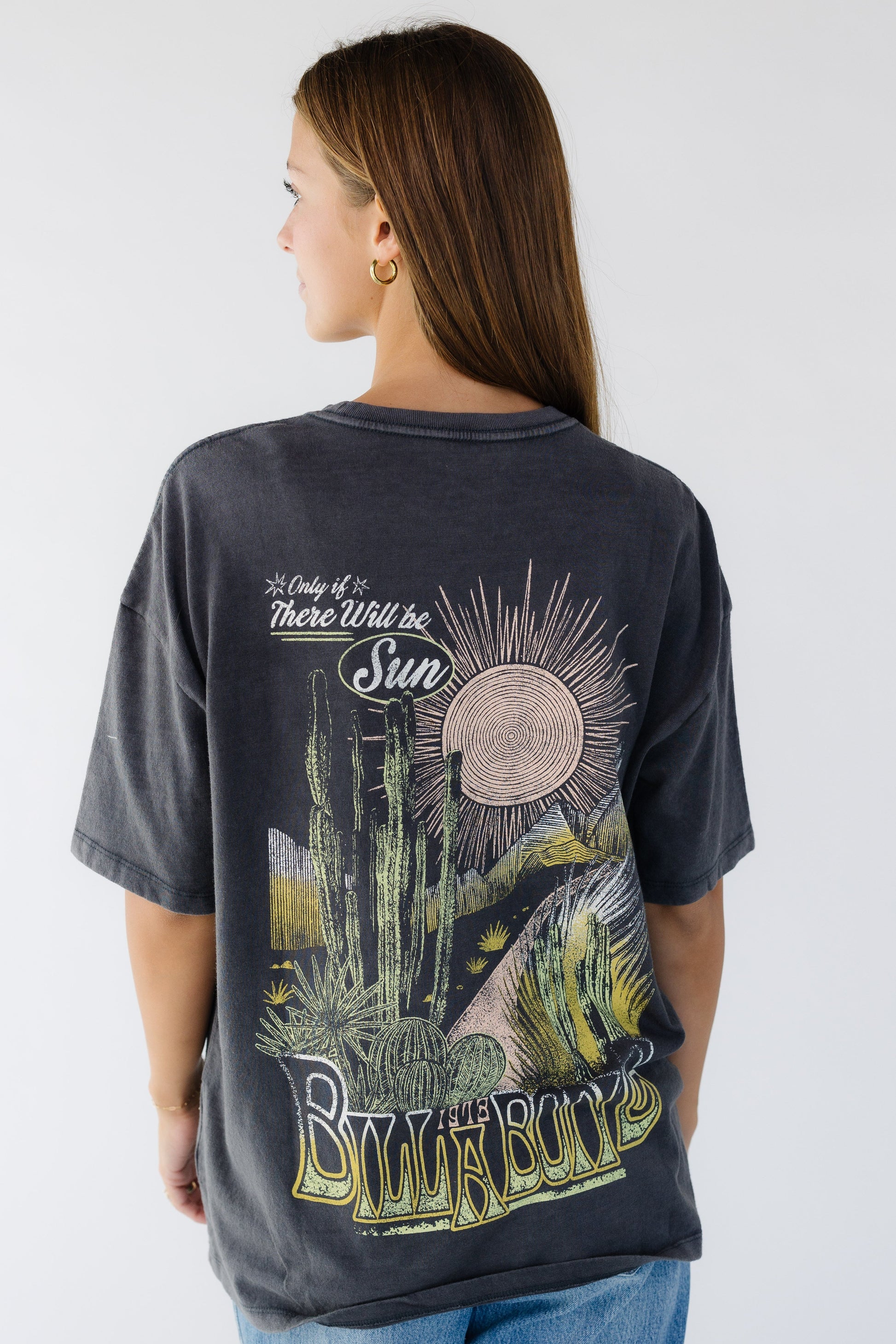 Young woman wearing a modest off black, loose fitting graphic tee.