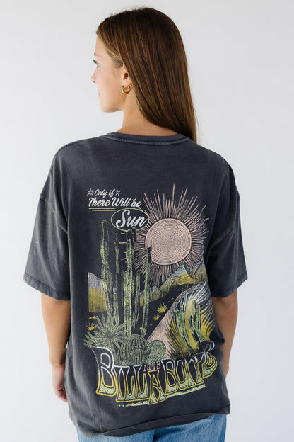 Young woman wearing a modest off black, loose fitting graphic tee.