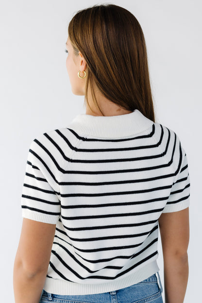 Back view of a young woman wearing a white & black stripe short sleeve sweater.