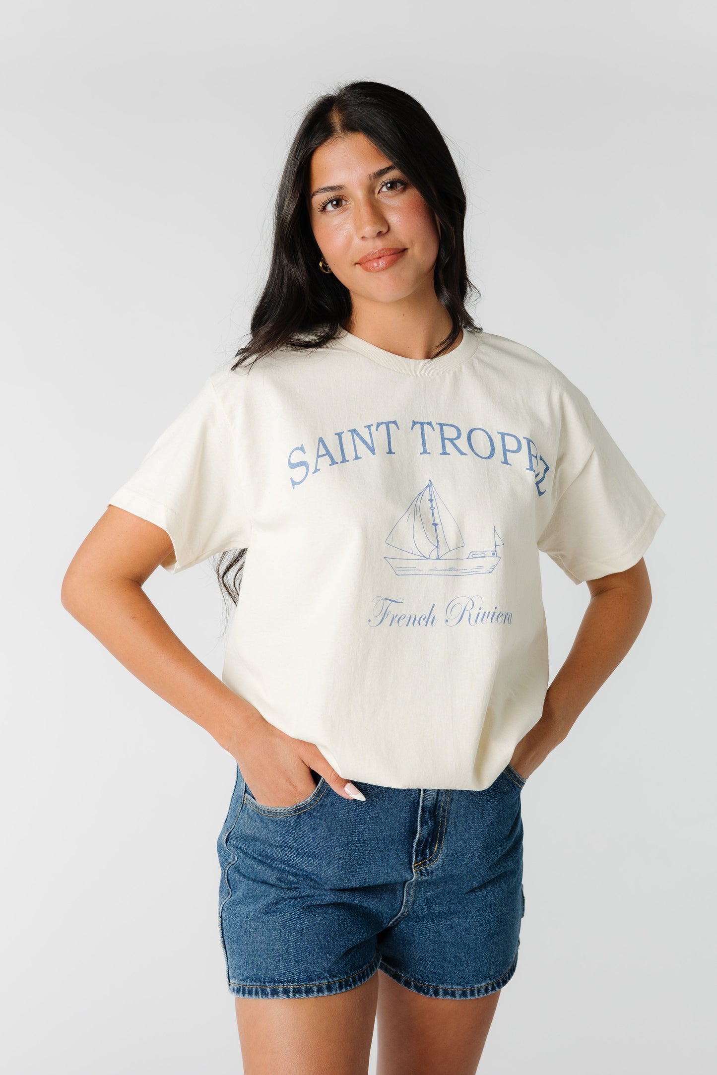 Women's off white  t-shirt  with blue graphic saying Saint Tropez