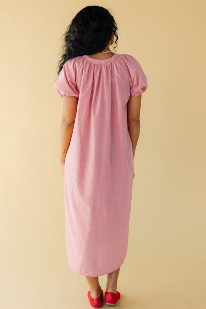 Back view of a woman wearing a red & white gingham midi dress with balloon sleeves.
