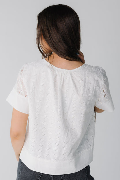 Back view of white eyelet loose fitting top with short sleeves