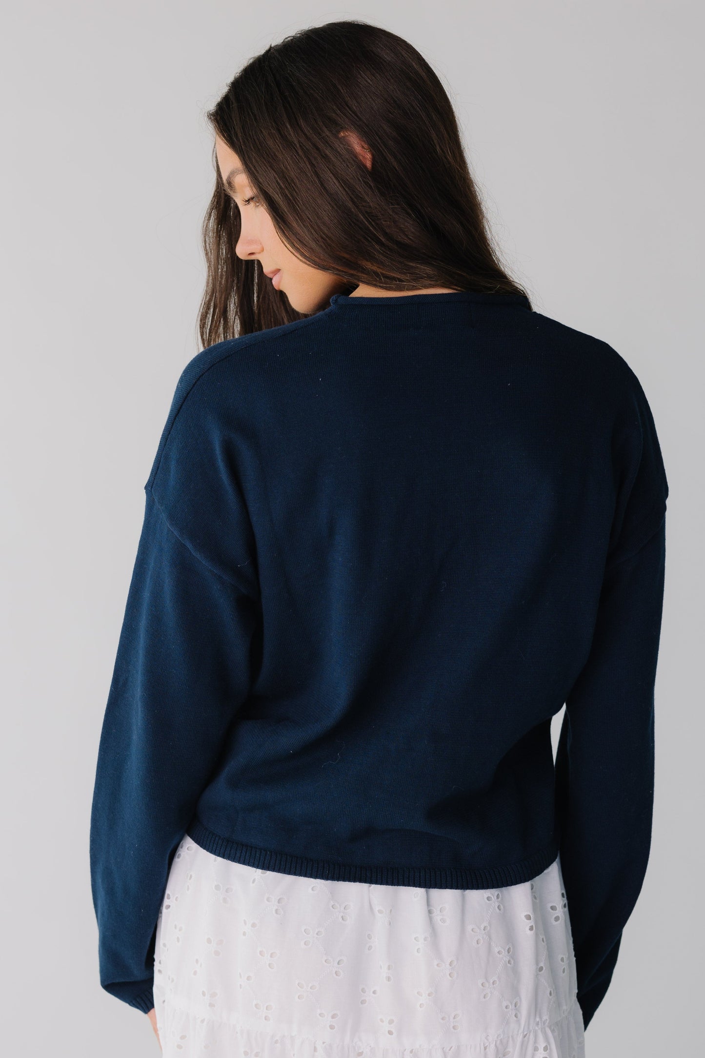 Back view of woman wearing long sleeve navy sweater
