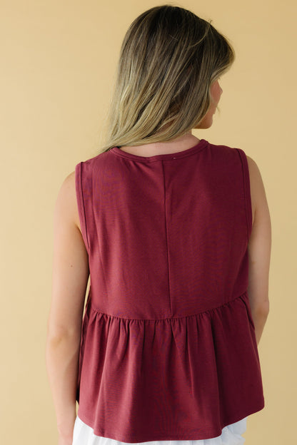 Back view of a young woman wearing a loose fitting sleeveless top in wine.