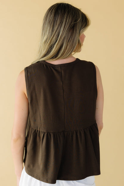 Back view of a young woman wearing a sleeveless bronw loose fitting top.