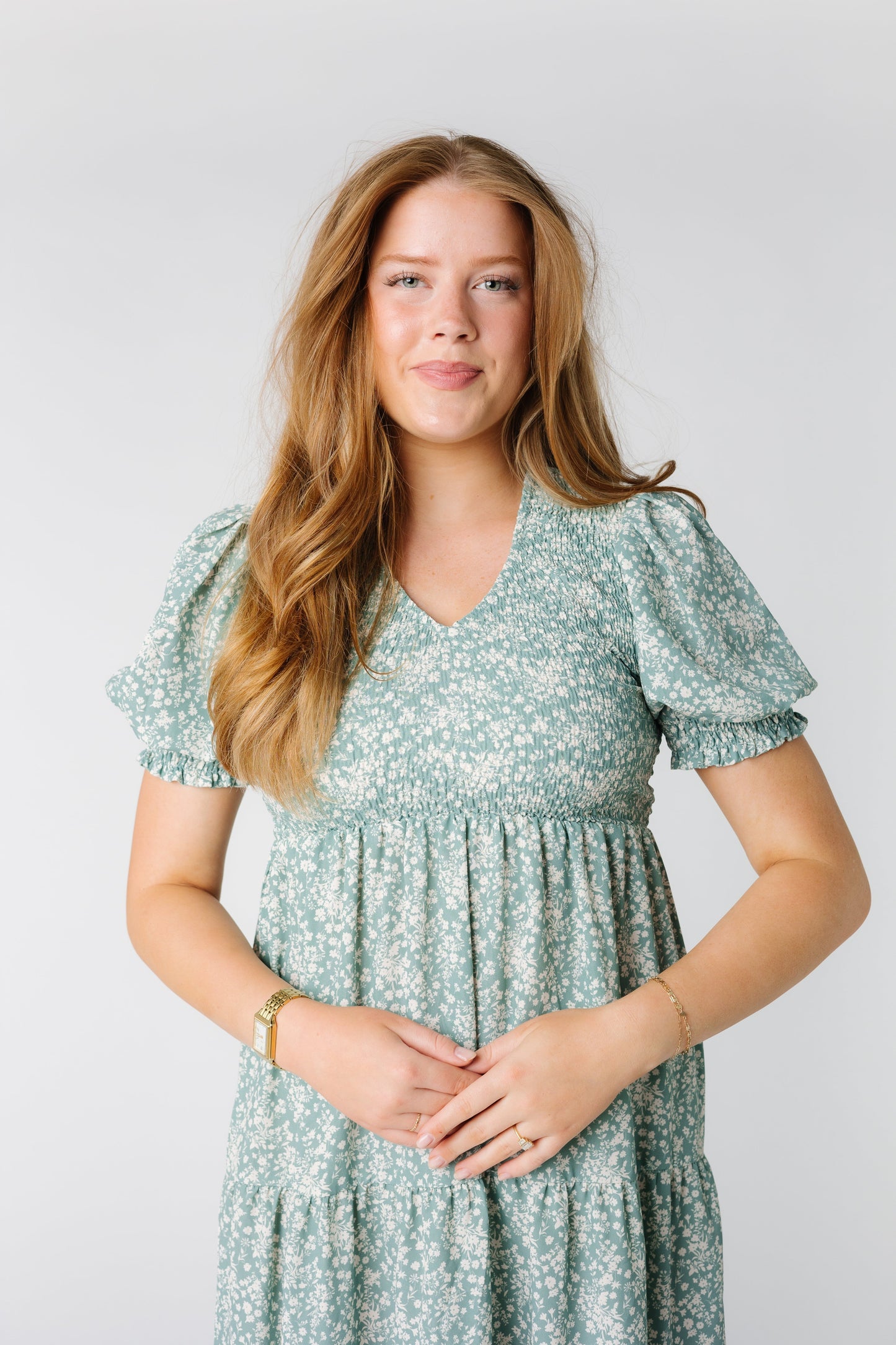 Close up photo of teal dress with V-neckline and puff sleeves