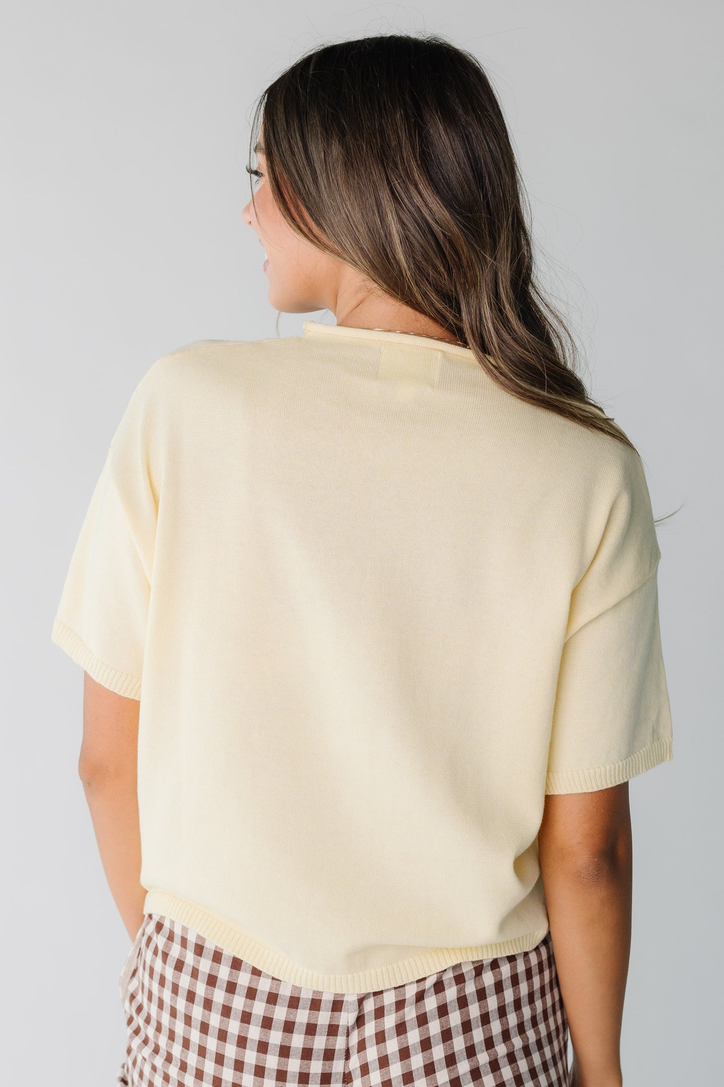 Back view of short sleeve yellow knit top for women