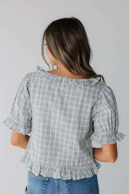 Back view of women's blue plaid top with ruffles