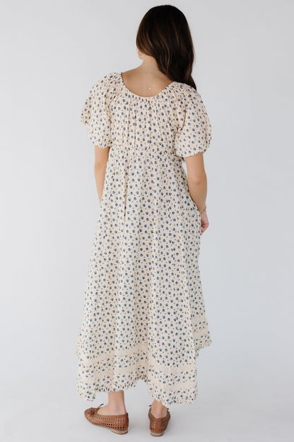 BAck view of awoman wearing a loose fitting dress with a balloon sleeves and a back scoop neckline.