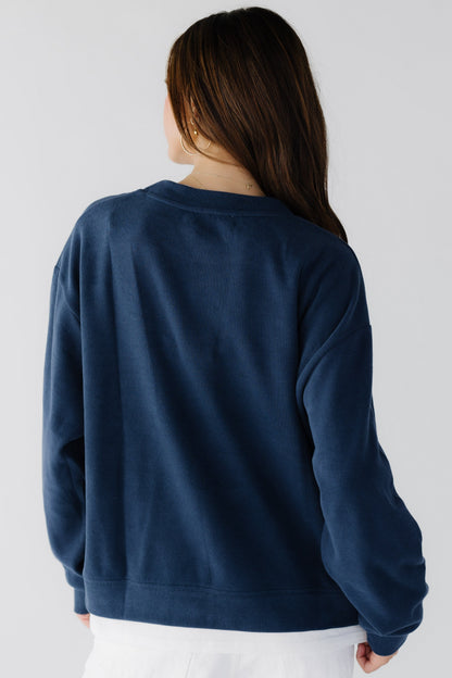 Back view of a woman wearing an oversized navy sweatshirt.