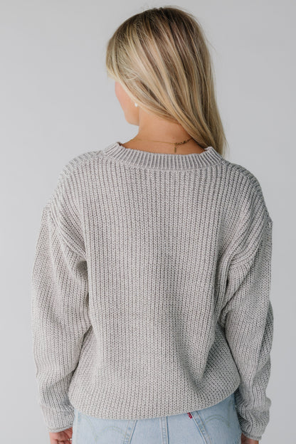 Back view of a woman wearing a light grey loose fitting sweater