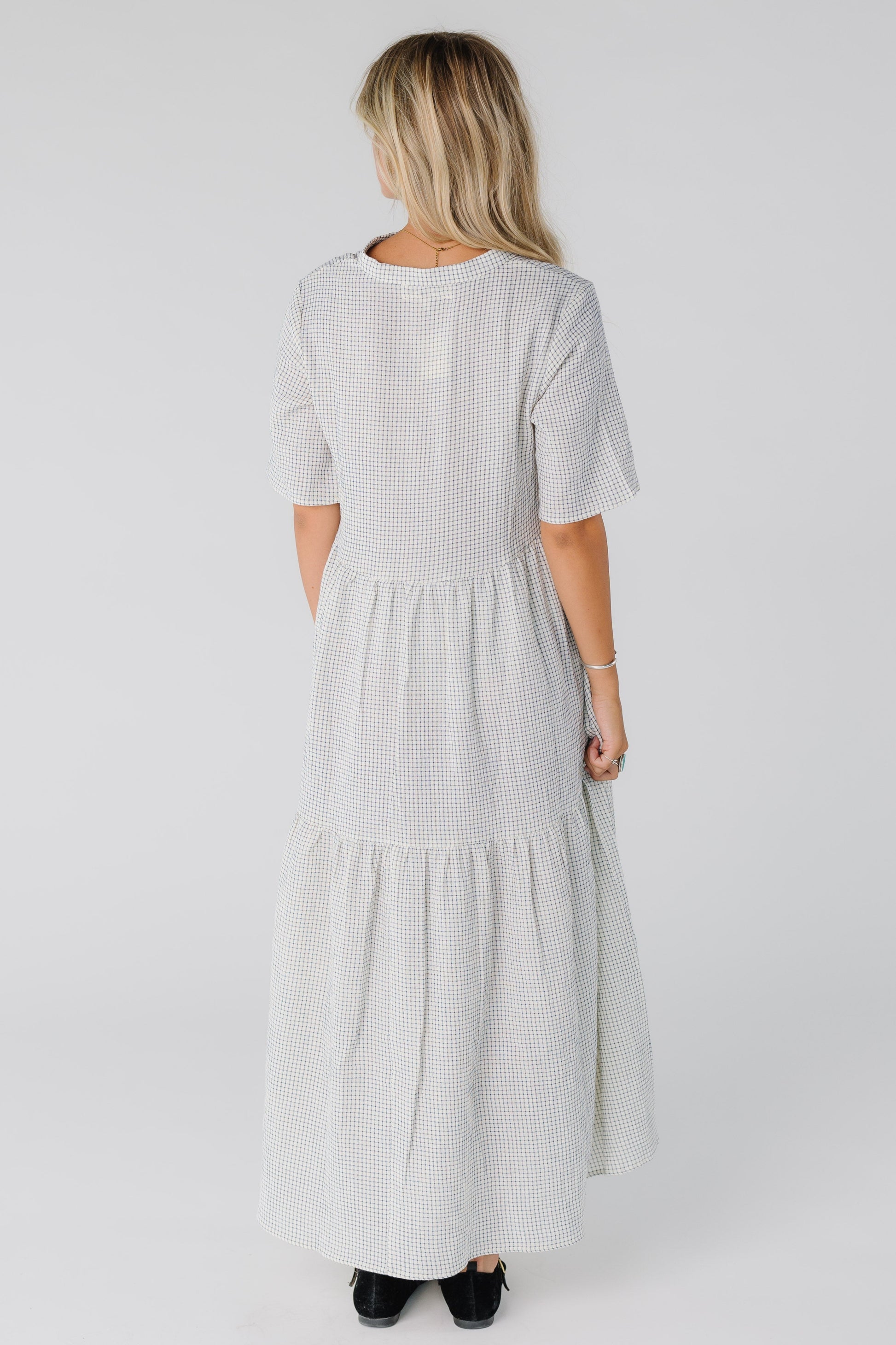 Back view of woman wearing white and black maxi dress with short sleeves