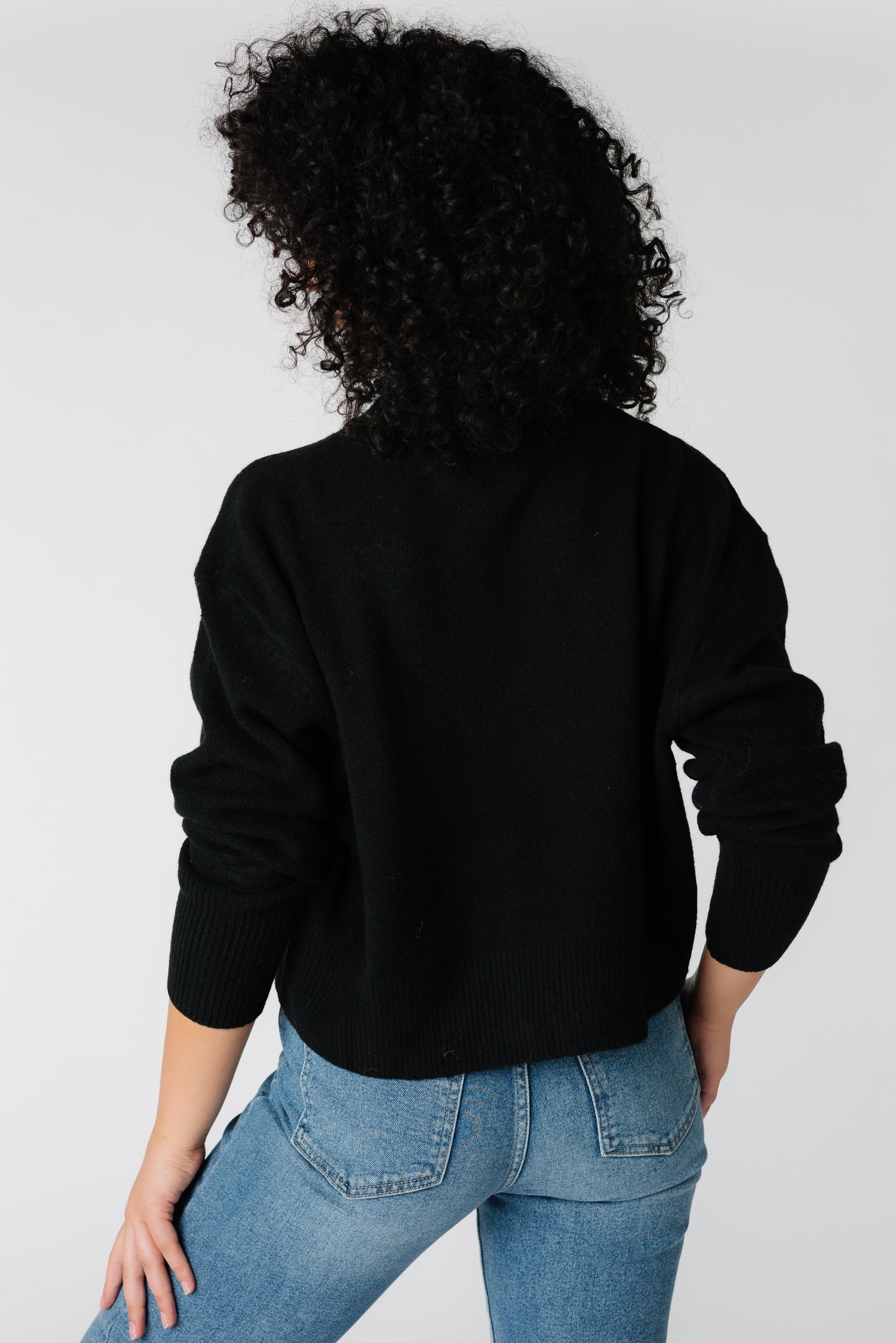 Back view of loose fitting black sweater