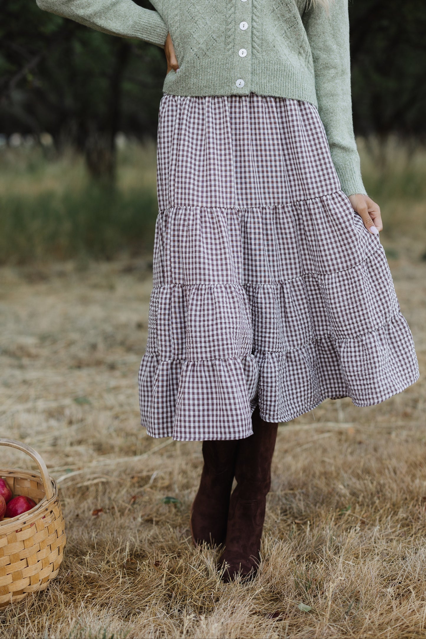 Young woman wearing a tiered midi skirt in brown gingham.
