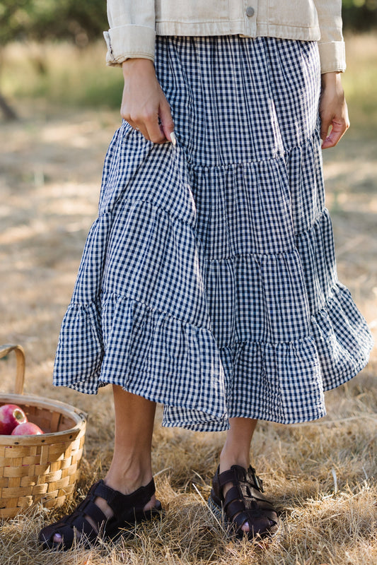 Young woman wearing a modest navy & white gingham tiered midi skirt.