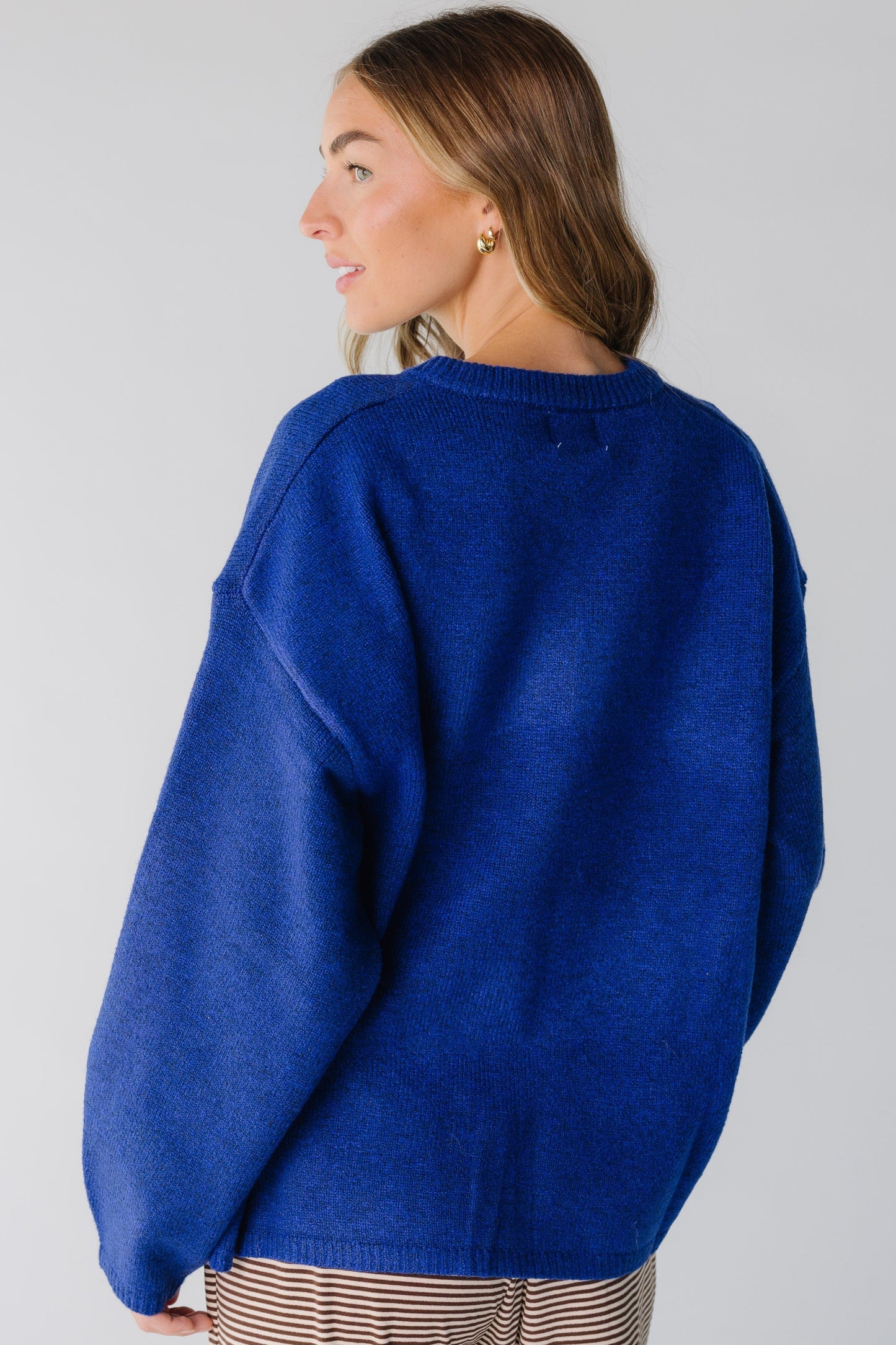 Back view of a woman wearing a royal blue cardigan with song sleeves