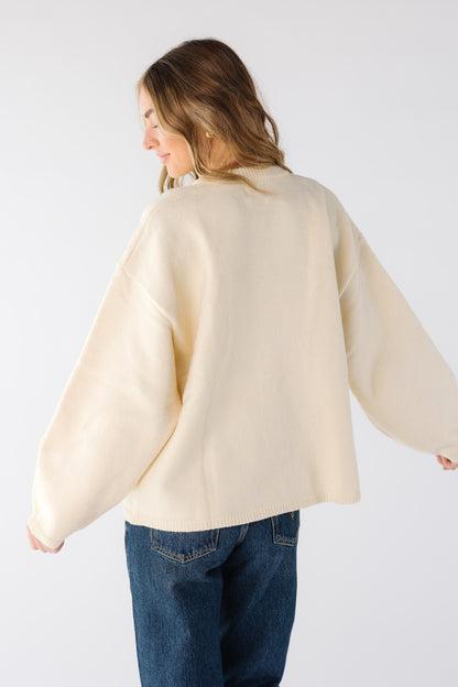 Back view of a woman wearing a loose fitting cream cardigan