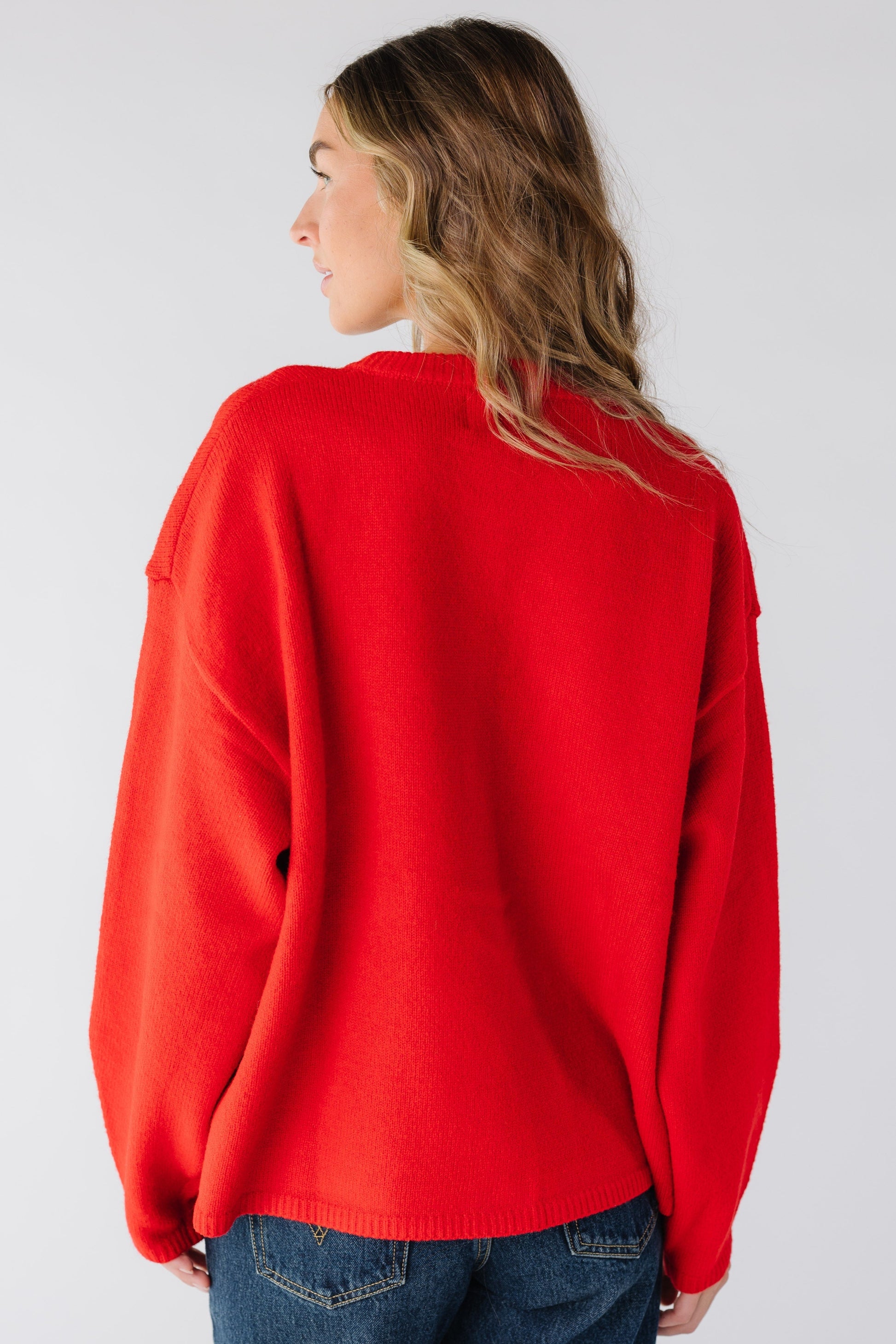 Back view of a woman wearing a red loose fitting cardigan