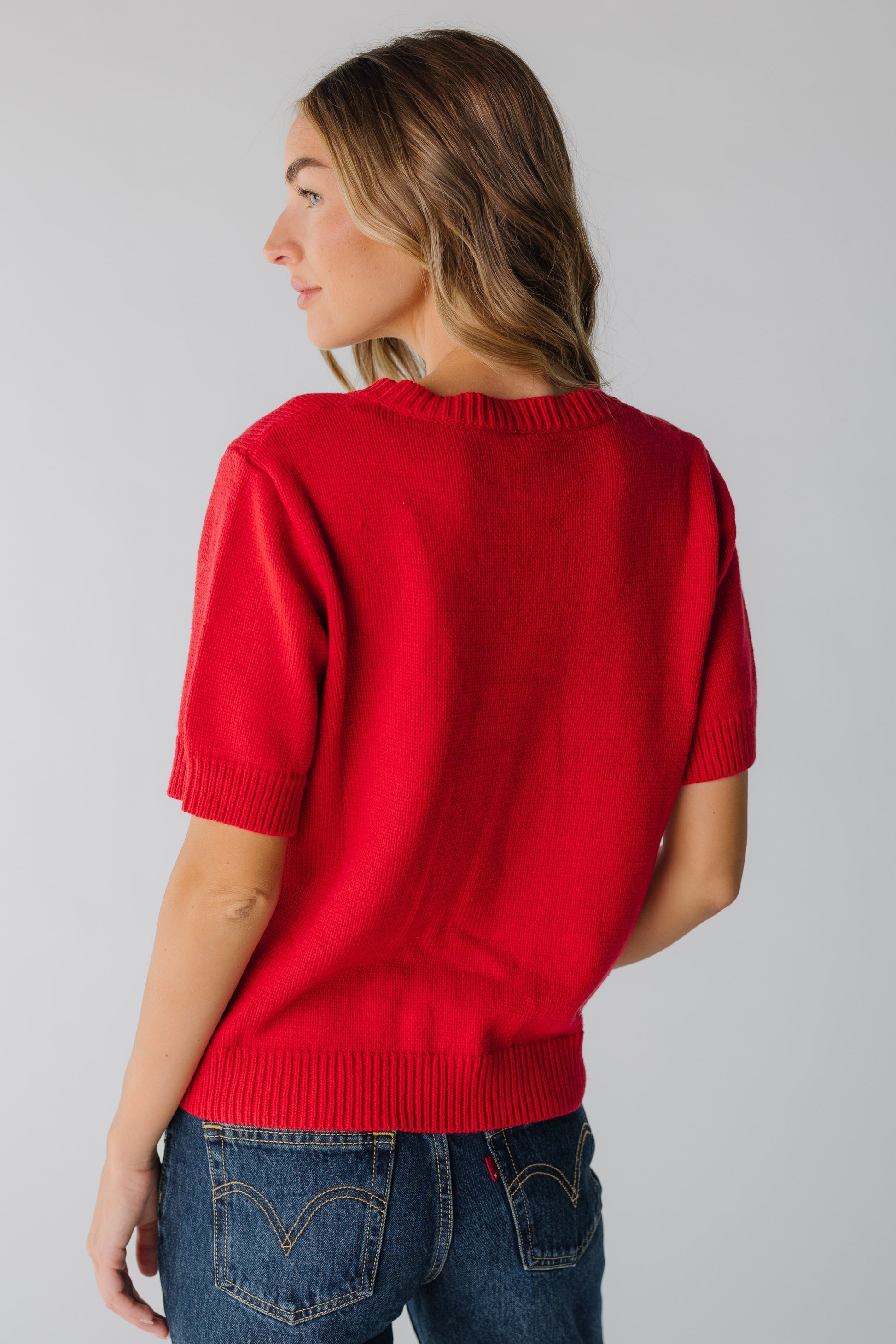 Back view of woman wearing red short sleeve sweater