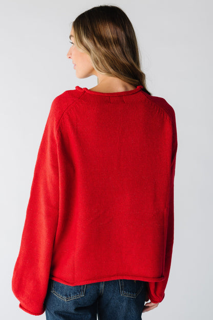 Back view of woman wearing a loose fitting red sweater with long sleeves