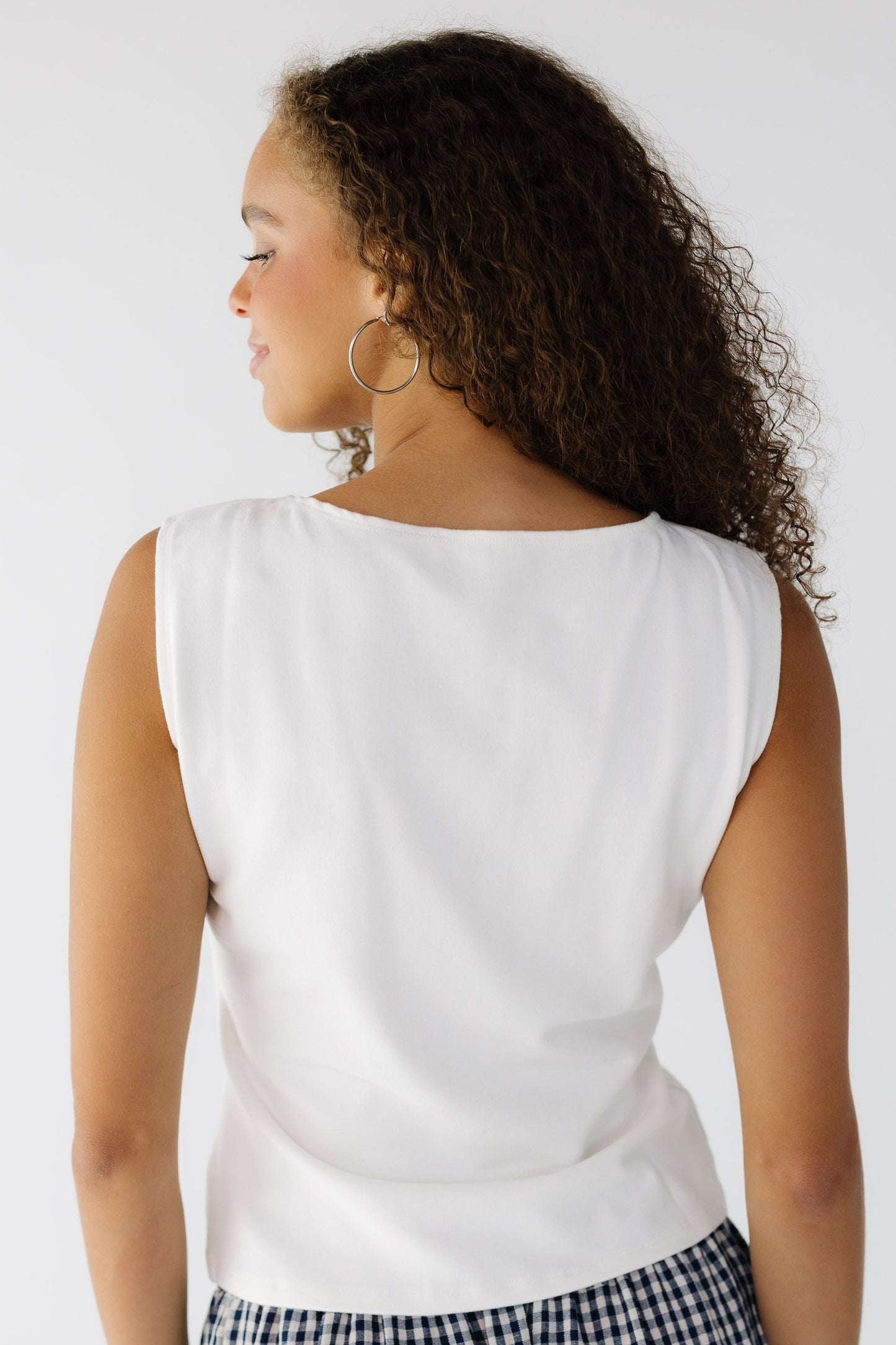 Back view of a teenage girl wearing a close fitting sleeveless top.
