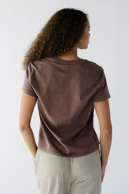 Back view of a woman wearing a brown short sleeve tee with a round neckline.