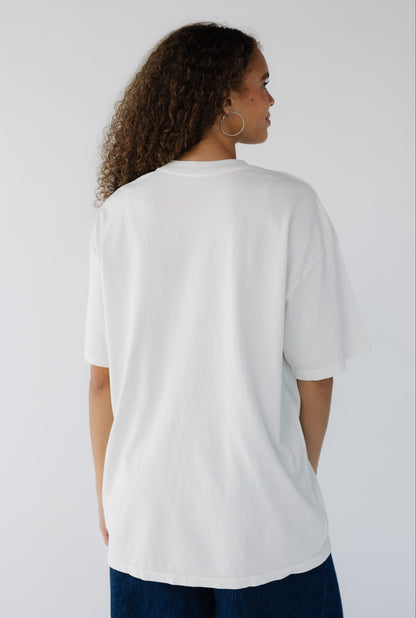 Teenage girls wearing a light cream oversized tee with short sleeves.