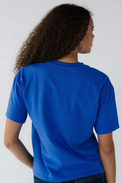 Back view of a teenage girl wearing a short sleeve tee in royal blue.