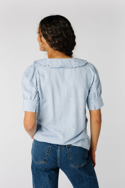 Back view of light blue short sleeve top with ruffle edge collar