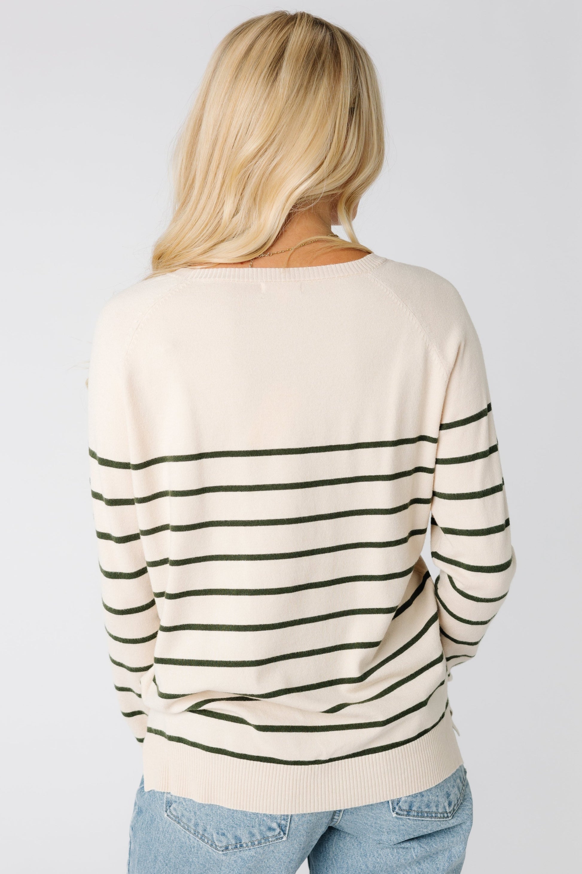 Back view of cream pullover sweater with dark green stripes