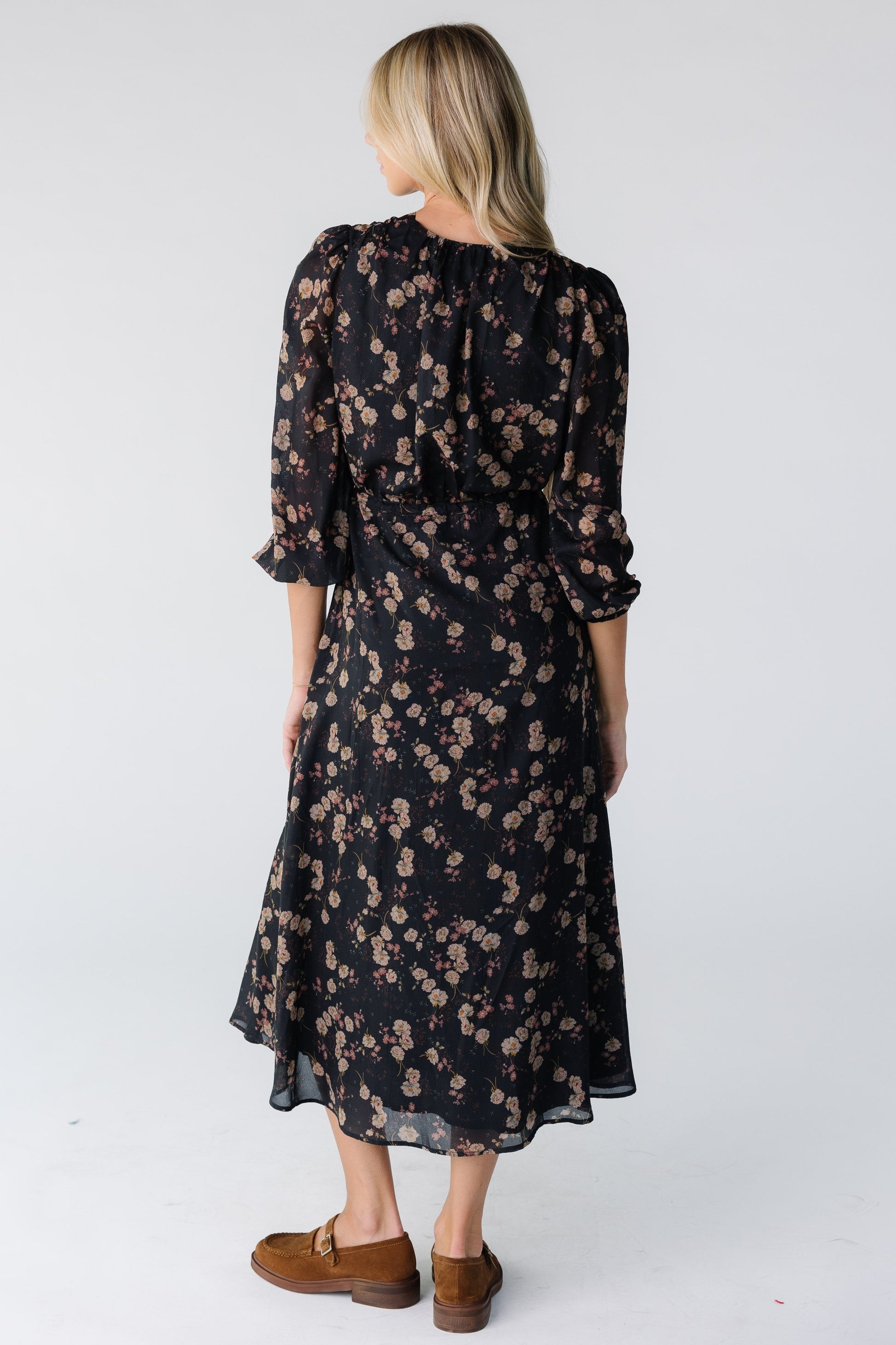 Back view of a woman wearing a black floral print midi dress
