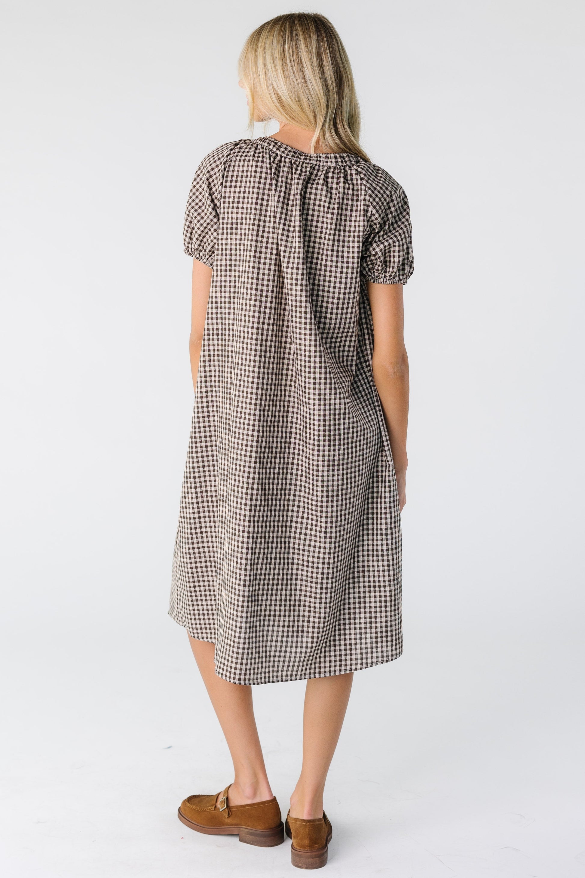 Back view of a woman wearing a brown gingham midi dress